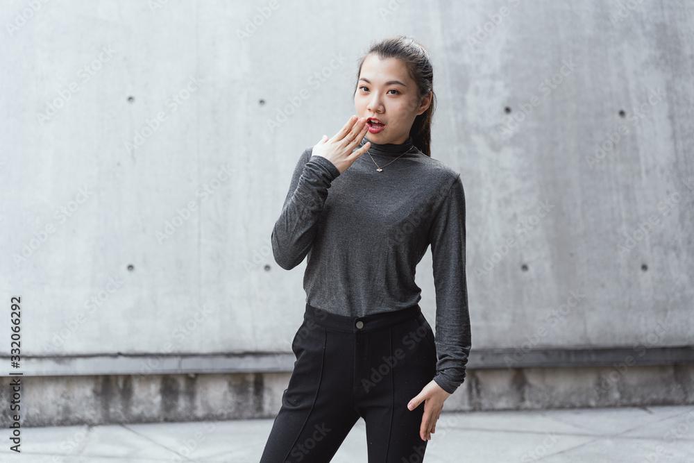 Asian young business women in front of gray walls Asian young business women in front of gray walls