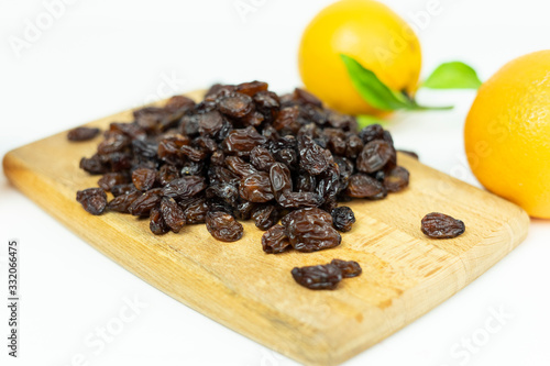 brown raisins on a wooden board on a white background