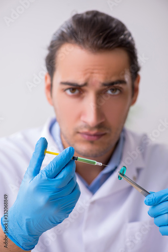 Young male lab assistant in drug synthesis concept