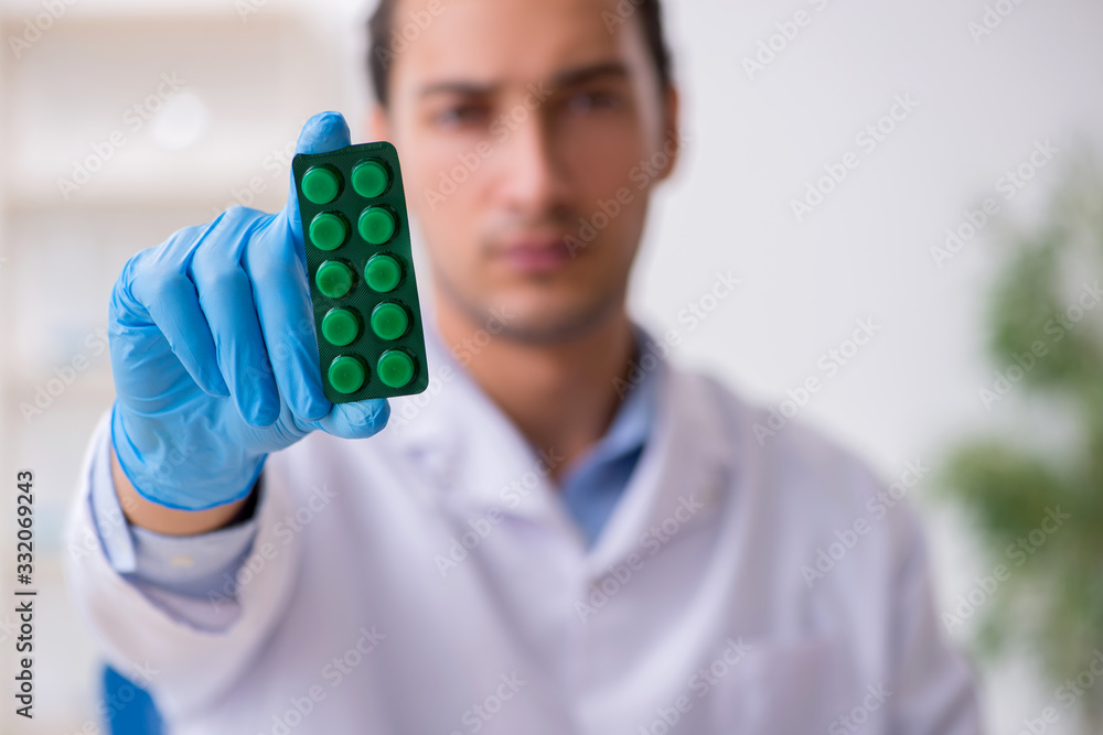 Young male lab assistant in drug synthesis concept Young male lab assistant in drug synthesis concept