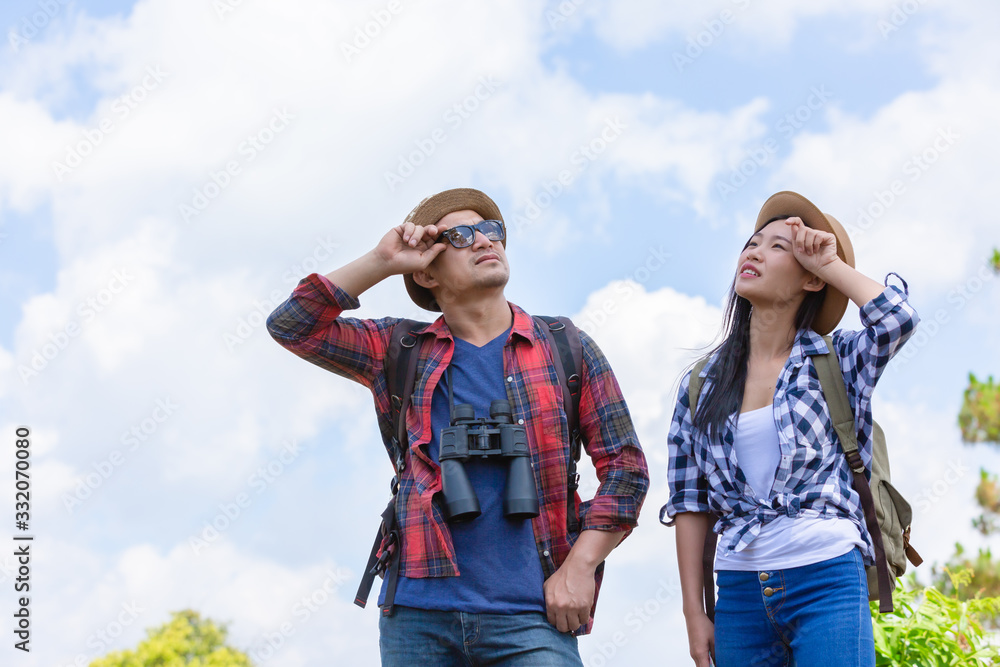 Young couple travel out with maps and binoculars with a backpack, feeling tired of traveling.
