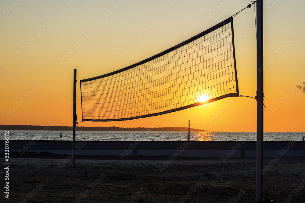 Sillhouette of a volleyball net against sunset on the beach Sillhouette of a volleyball net against sunset on the beach