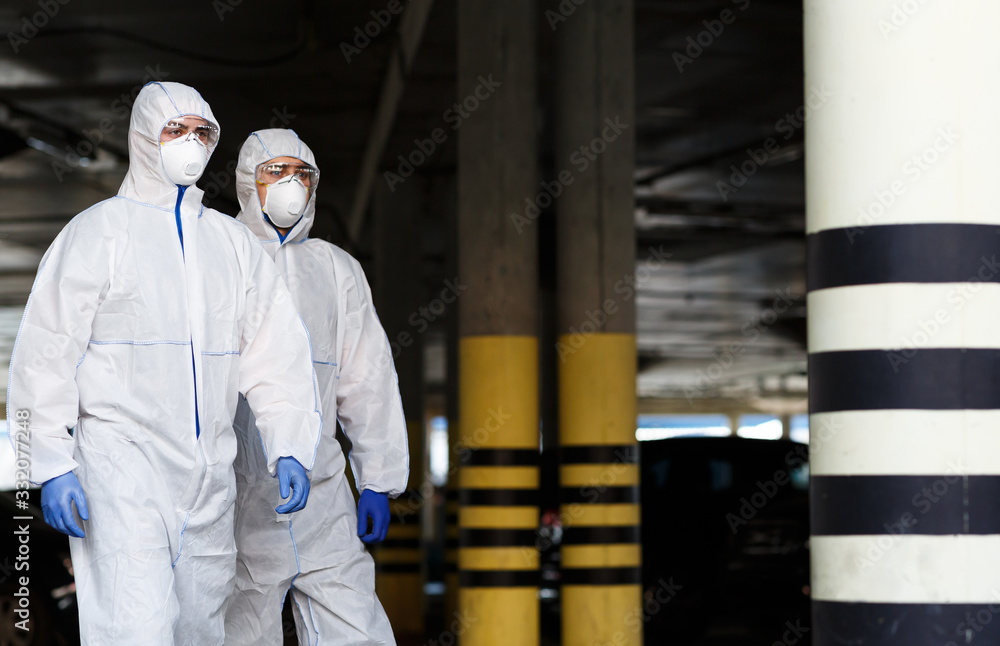 Men in virus protective suits patrol the city while quarantine Men in virus protective suits patrol the city while quarantine