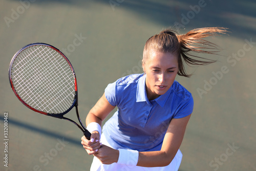 Top view of beautiful tennis player ready to serving the ball on the tennis court.