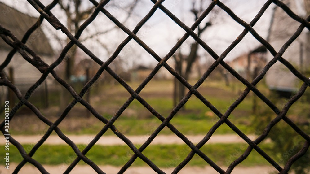 view of the landscape through an iron mesh view of the landscape through an iron mesh