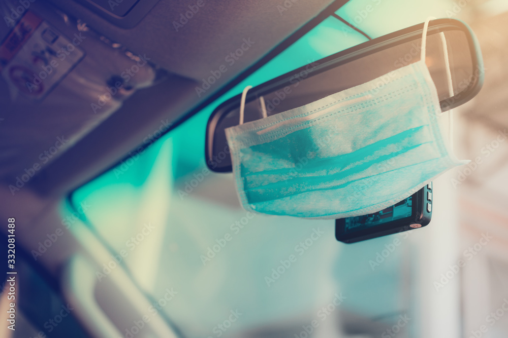 Hygienic masks hanging on the windshield on the inside of the car, where the sunlight comes in.protection from corona virus or COVID-19 concept.