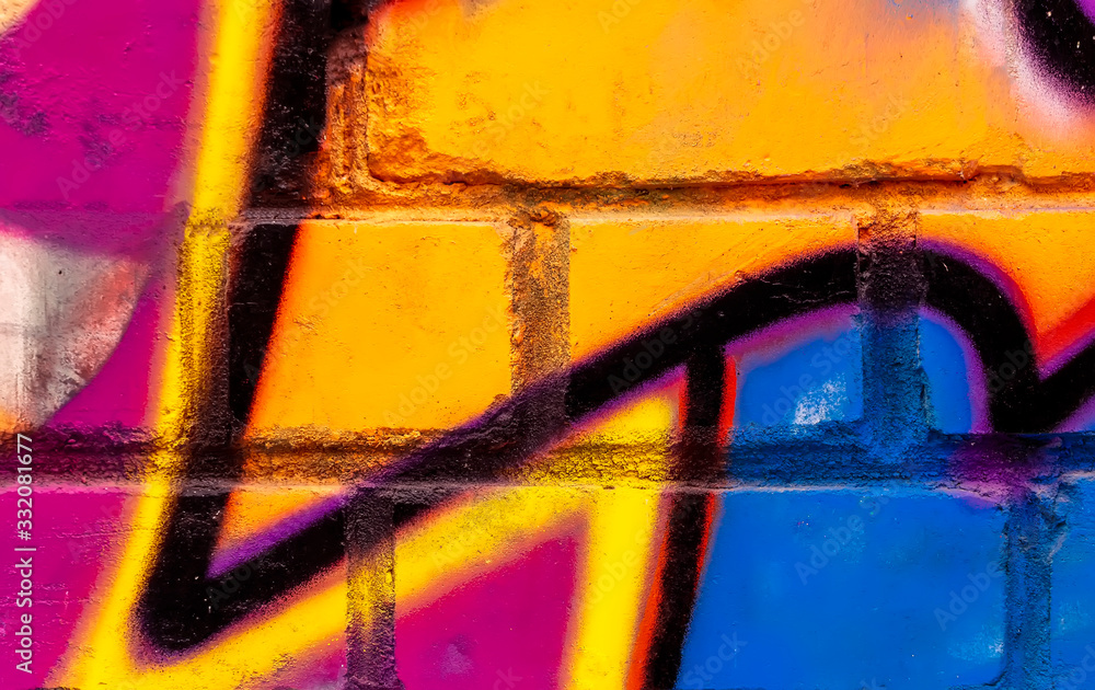Beautiful bright colorful street art graffiti background. Abstract creative spray drawing fashion colors on the brick walls of the city. Urban Culture ,blue, red , yellow , orange texture