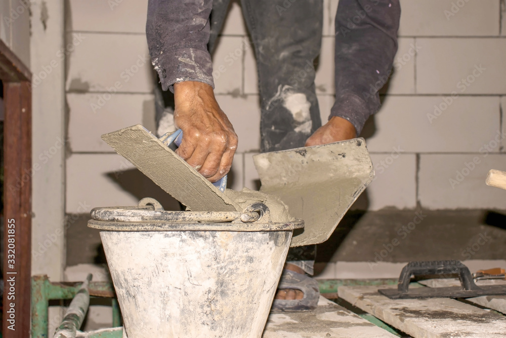 Close-up of the construction worker is mixing cement for plastering for the house and building construction.