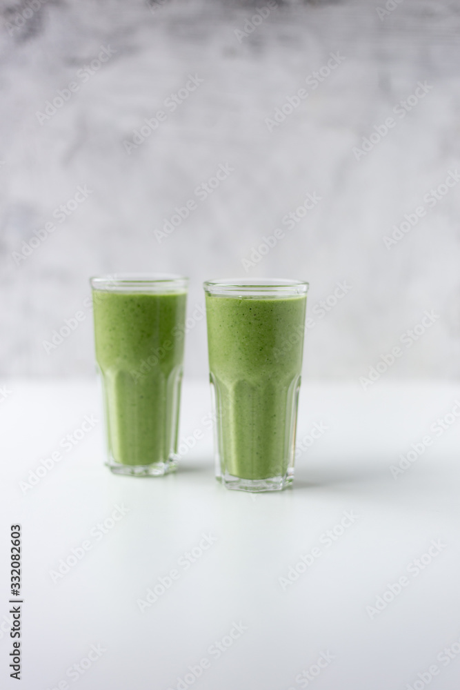Green detox juice on white marble background with copy space. Vegan detox concept. Green detox juice on white marble background with copy space. Vegan detox concept.