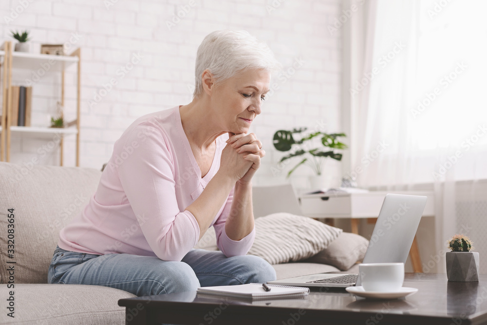 Sad senior lady looking at laptop with perplexity Sad senior lady looking at laptop with perplexity