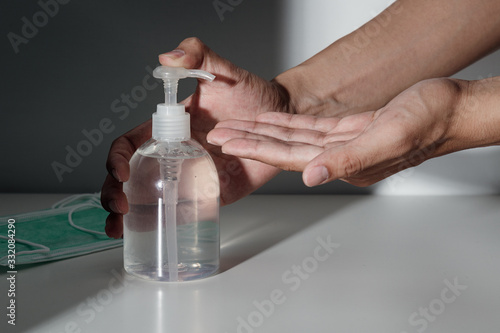 Hands using alcohol sanitizer gel pump and medical surgical masks for prevent infection, Covid-19 or corona virus, Coronavirus prevention.