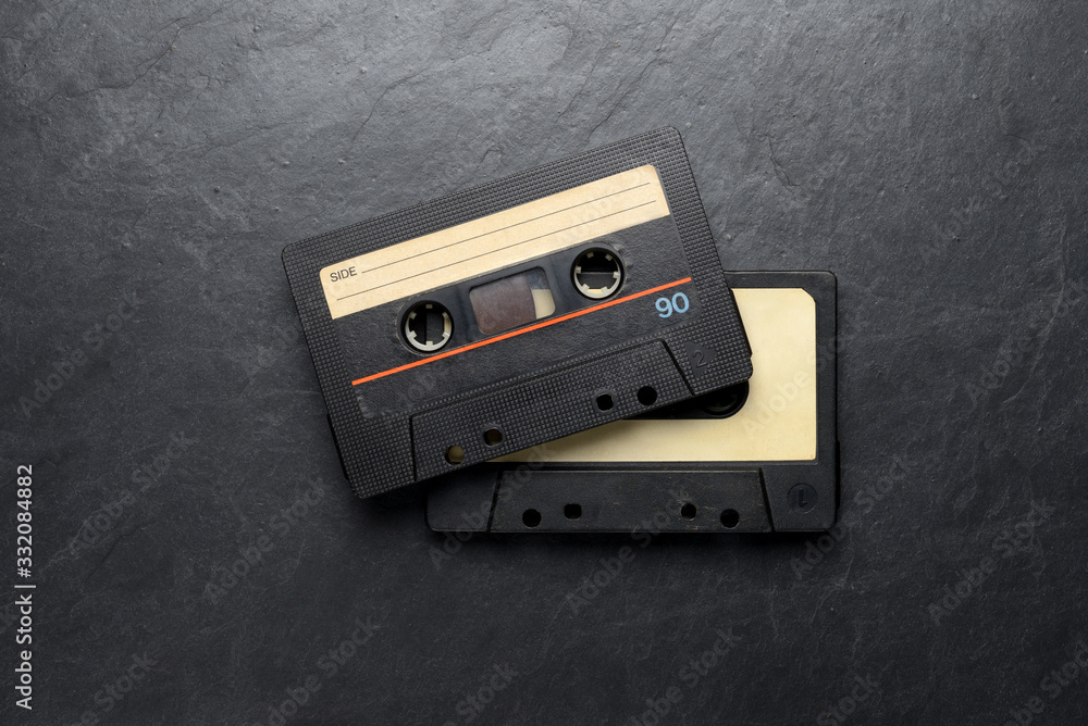 Fototapeta premium Black audio tape compact cassettes on black background