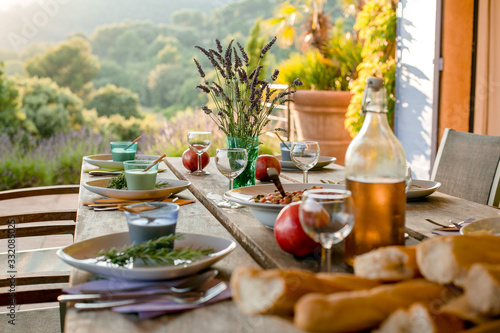 Φωτογραφία Dinner is served at a wooden table on the veranda with a bottle of rose wine and