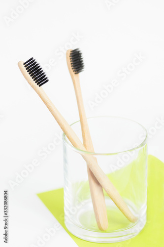 Eco wooden toothbrush in glass on white. Zero waste and green lifestyle concept