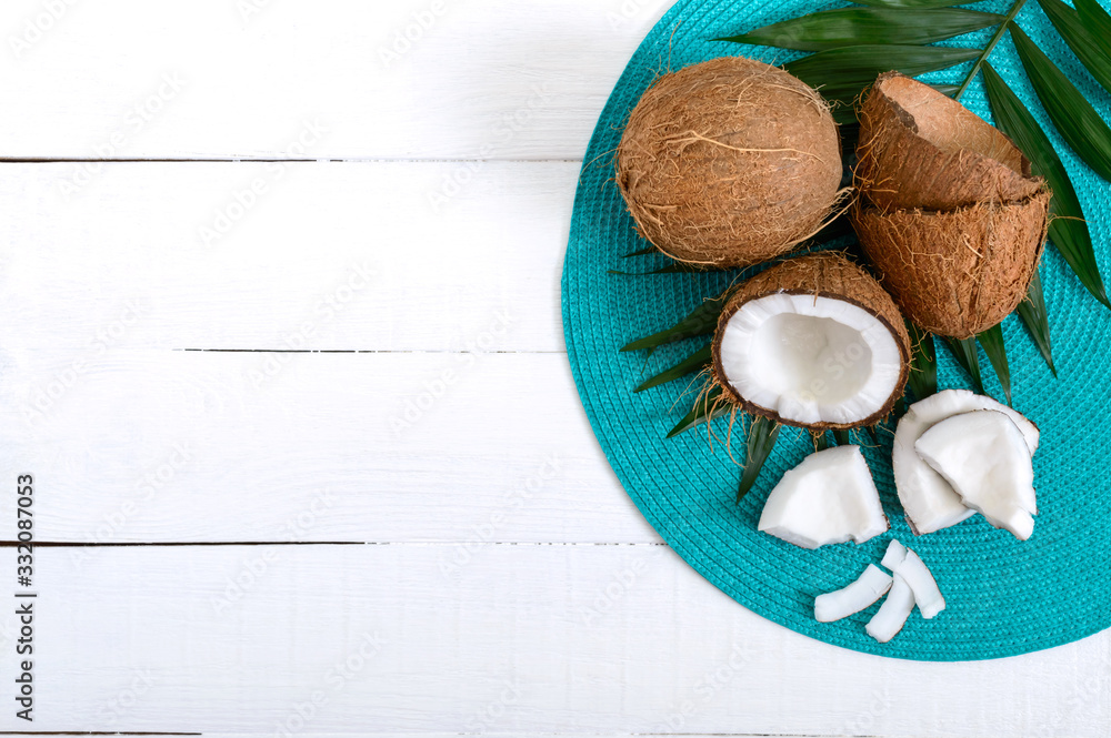 Coconut. Whole coconut, shell and green leaves on a white wooden background. Big nut. Tropical fruit coconut in the shell. SPA. Food photo. Photo background. Texture tropical fruit. Copy spase. Coconut. Whole coconut, shell and green leaves on a white wooden background. Big nut. Tropical fruit coconut in the shell. SPA. Food photo. Photo background. Texture tropical fruit. Copy spase.