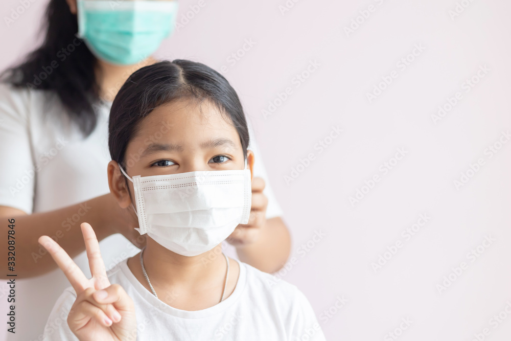 Asian little girls wear medical protective masks and raise 2 fingers Asian little girls wear medical protective masks and raise 2 fingers