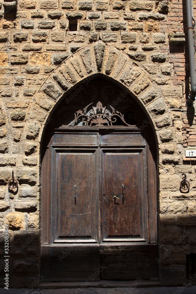 Volterra (SI), Italy - April 25, 2017: An old typical wood door in Volterra town, Tuscany, Italy