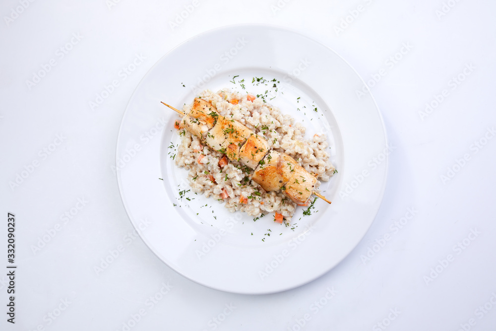 chicken kebab with barley on the white plate