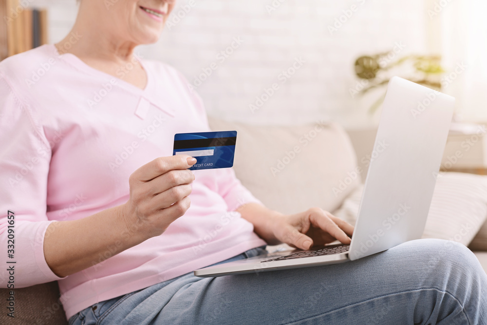 Senior woman checking her credit card balance at home Senior woman checking her credit card balance at home