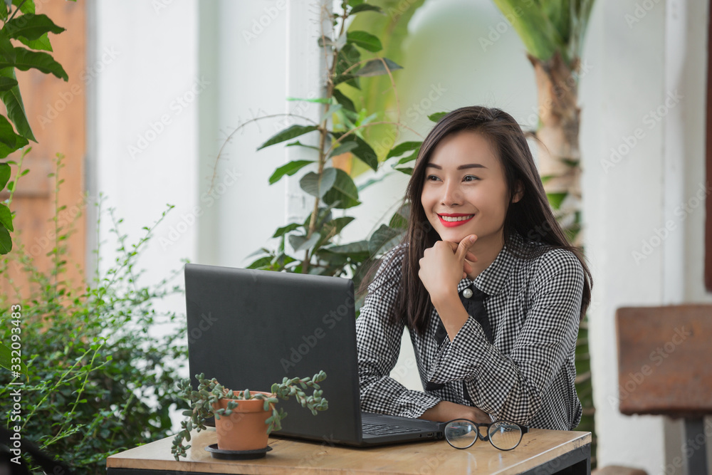 Smiling businesswoman working on laptop in cafe Smiling businesswoman working on laptop in cafe