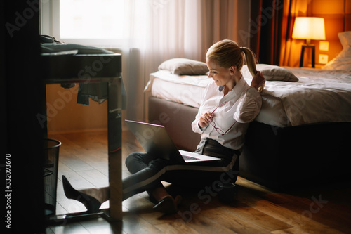 Businesswoman working from a hotel room. Beautiful young woman working on lap top.