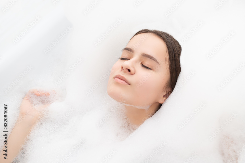 Beauty, spa, personal care. Young woman relaxes in the bath with foam Beauty, spa, personal care. Young woman relaxes in the bath with foam