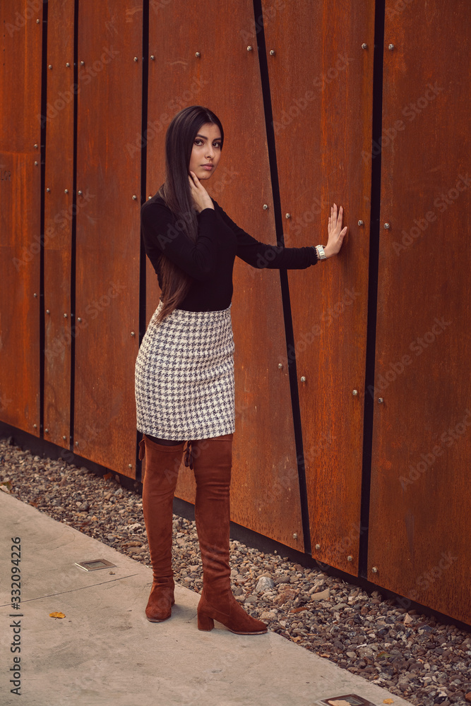 Beautiful girl model posing against the background of the modern building