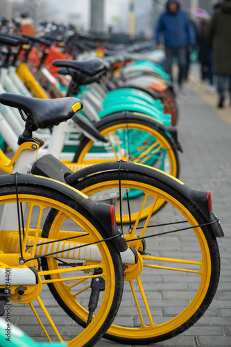 Rental bicycles are brightly for urban ride-sharing and Commuting, lined up on the sidewalks in large cities.