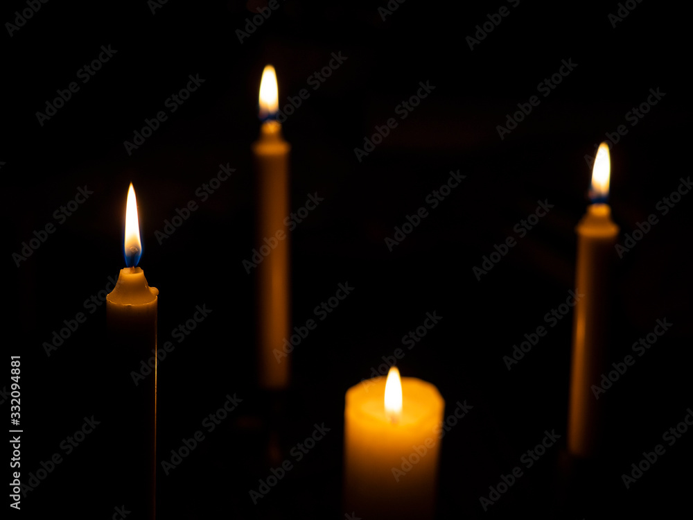 Burning candles with focus on the foreground candle Burning candles with focus on the foreground candle