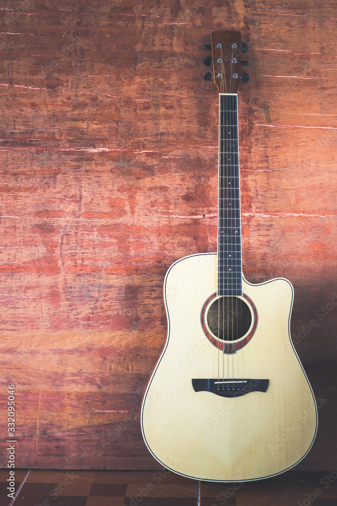 Naklejka premium Guitar on wooden wall