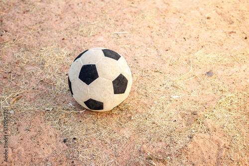 Old football on the dry grass in evening