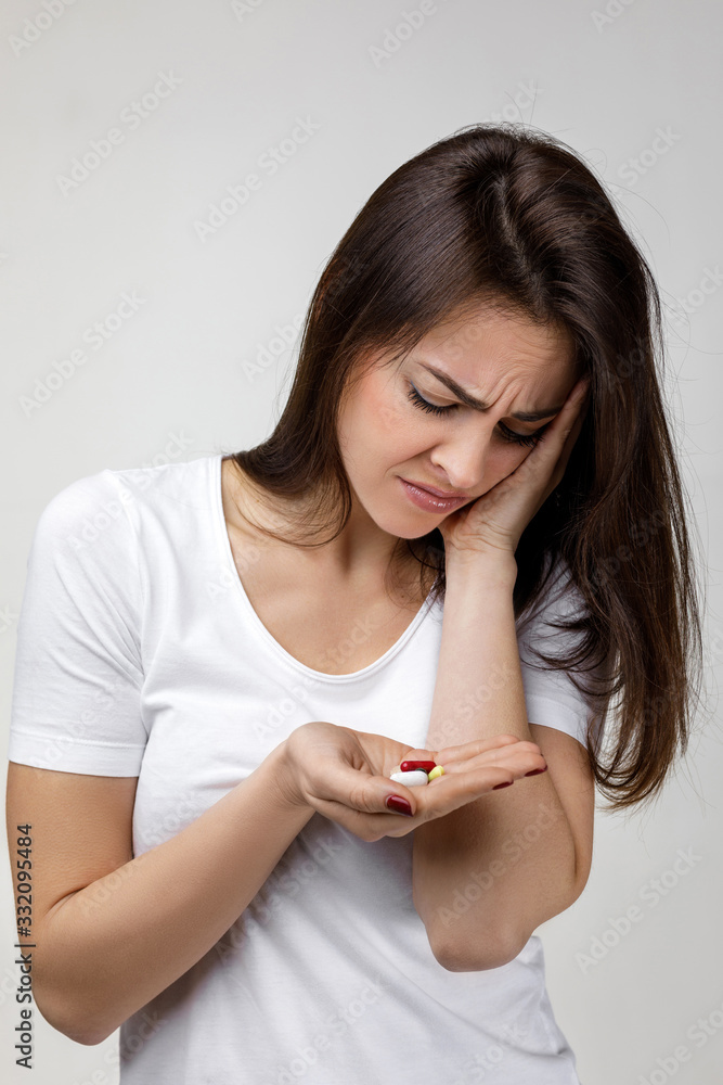 young sad woman with medicine suffering from tooth pain, caries. girl having toothache and taking pill. Dental health and care concept young sad woman with medicine suffering from tooth pain, caries. girl having toothache and taking pill. Dental health and care concept