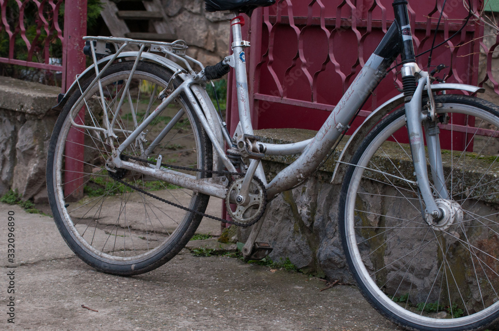 A gray woman's bicycle leaning against a metal railing