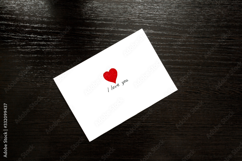 Rectangular envelope with a heart on the wooden table top. Love letter.