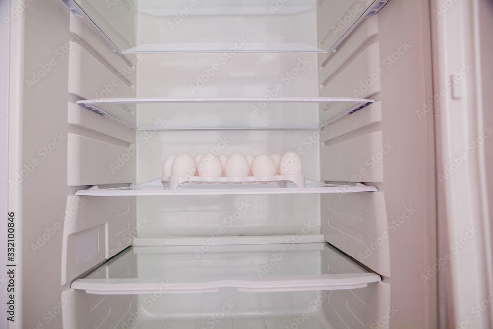 Chicken eggs standing on the empty shelf of the refrigerator in the egg tray Chicken eggs standing on the empty shelf of the refrigerator in the egg tray
