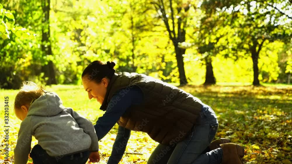 Young mother having fun with her son in autumn park Young mother having fun with her son in autumn park
