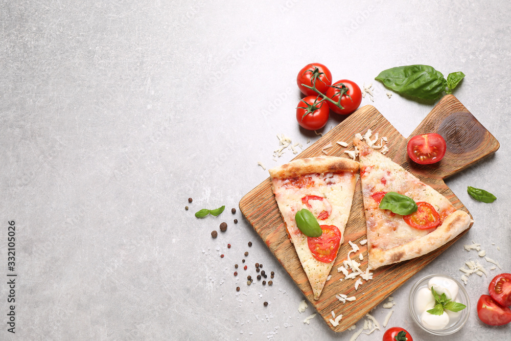 Slices of delicious pizza Margherita on light grey table, flat lay. Space for text Slices of delicious pizza Margherita on light grey table, flat lay. Space for text