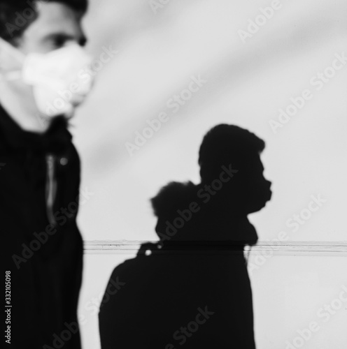 silhouette of a man in a protective mask against coronavirus against the wall.