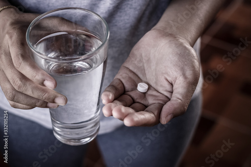 Close up of girl holding paracetamol and glass of water. photo