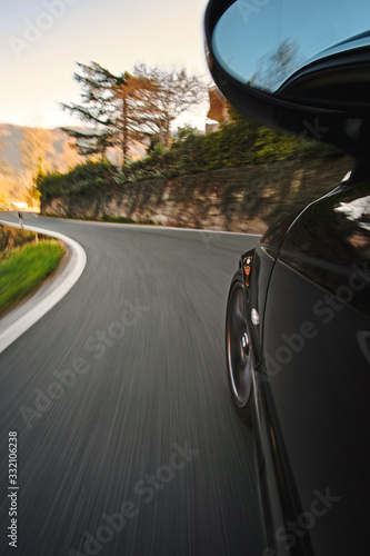 mersive view of a moving car on the road focus on tire and corner