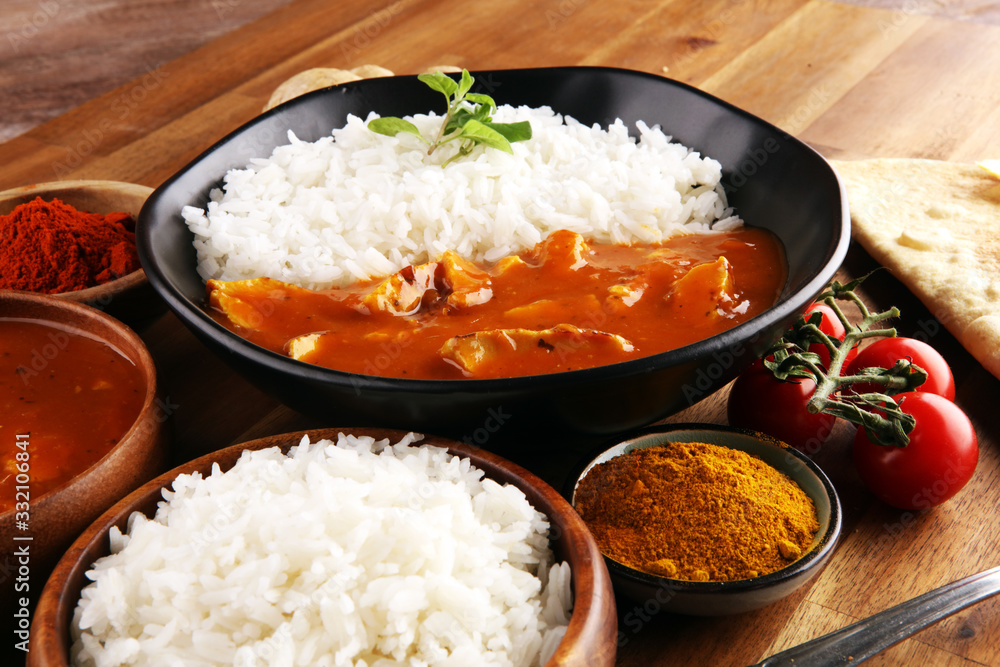 Chicken tikka masala spicy curry meat food in pot with rice and naan bread. indian food on table Chicken tikka masala spicy curry meat food in pot with rice and naan bread. indian food on table