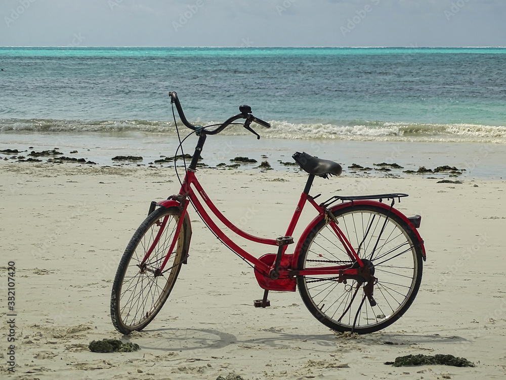 Obraz premium Rotes Fahrrad Damenfahrrad am Strand in Afrika