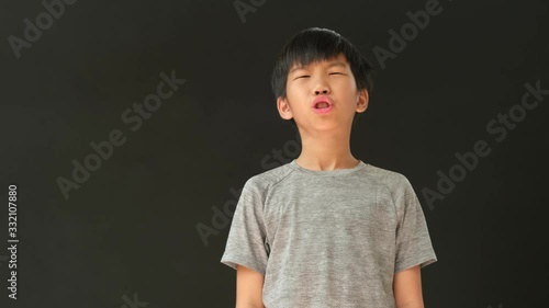 4k young Asian boy has sneeze on black background