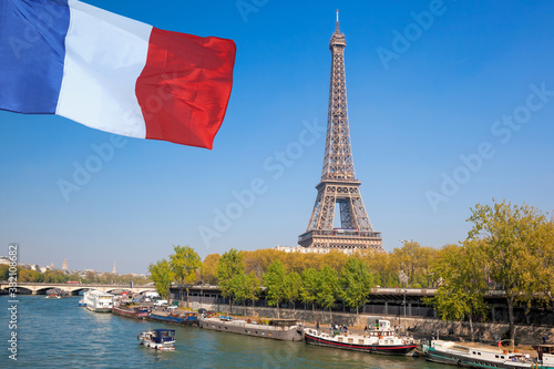 Paris with Eiffel Tower against french flag during spring time in France