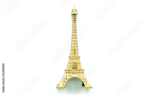 The small golden Eiffel tower as a souvenir from Paris. Isolated on a white background. 