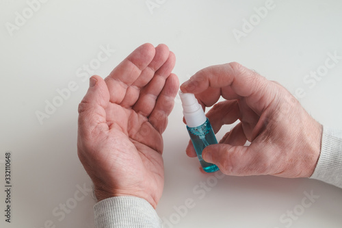Hand treatment with an antiseptic drug. Men's hands with a bottle of hand handling in the frame. Coronavirus, hygiene concept. Horizontal orientation. Selective focus. View from above.