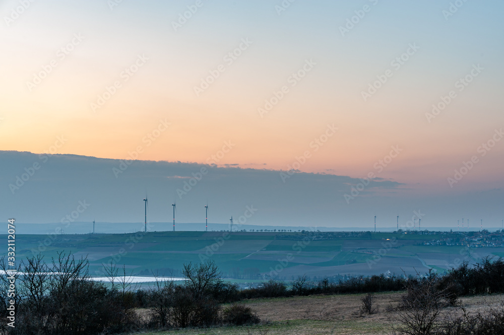 wind turbines in a hilly landscape at dusk