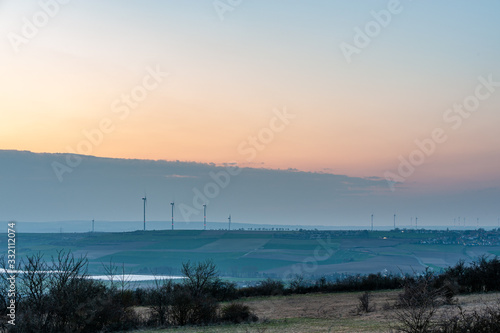 Fototapeta Naklejka Na Ścianę i Meble -  wind turbines in a hilly landscape at dusk