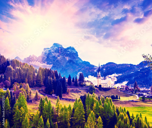 Obraz na płótnie Amazing magical spring unbeatable landscape with the church and yellow larch on a background of mountains in the Dolomites in a sunny day near Codalonga, Alps, Italy. w salonie