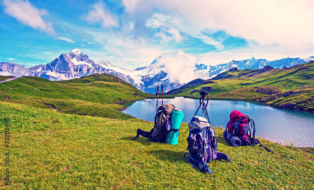 Backpacks, trekking pole and camera on a tripod in the mountains in the Swiss Alps, Europe (still life coach, company, friendship, background - concept)
